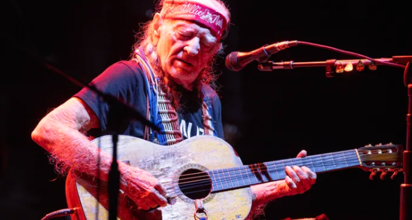 Photo of Willie Nelson performing at Outlaw Music Festival
